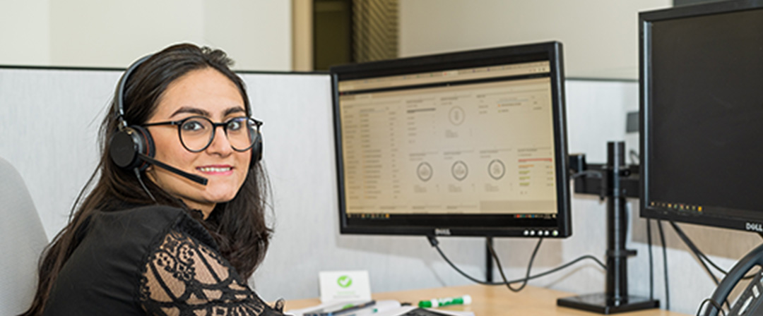 A woman wearing glasses is working on the computer