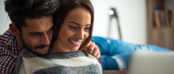 Couple smiling looking at laptop